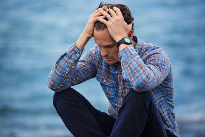 Opioid addiction affects frustrated Man holding his head.