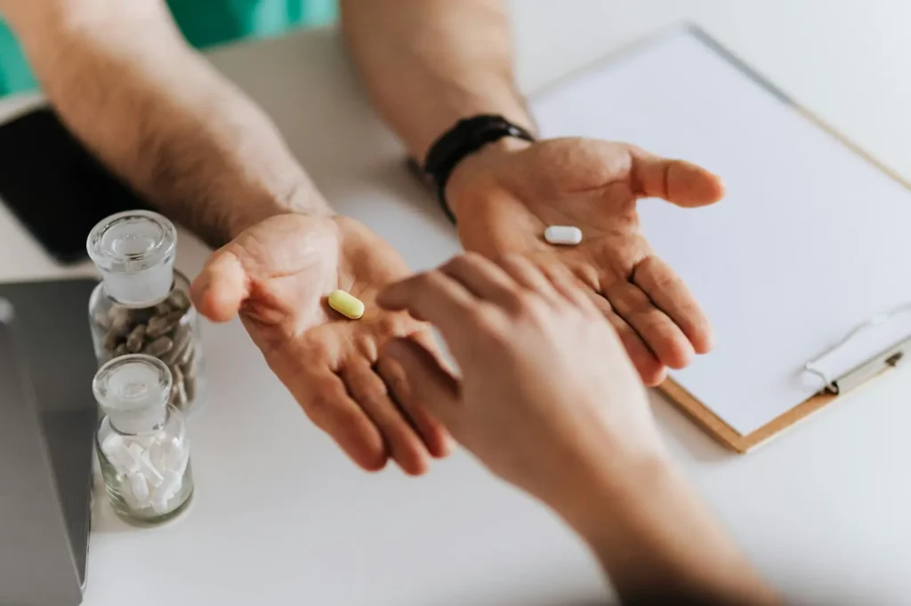 Can you take ibuprofen with meloxicam? A person, palms up, with a pill in each hand. Another person reaches for one of the pills.