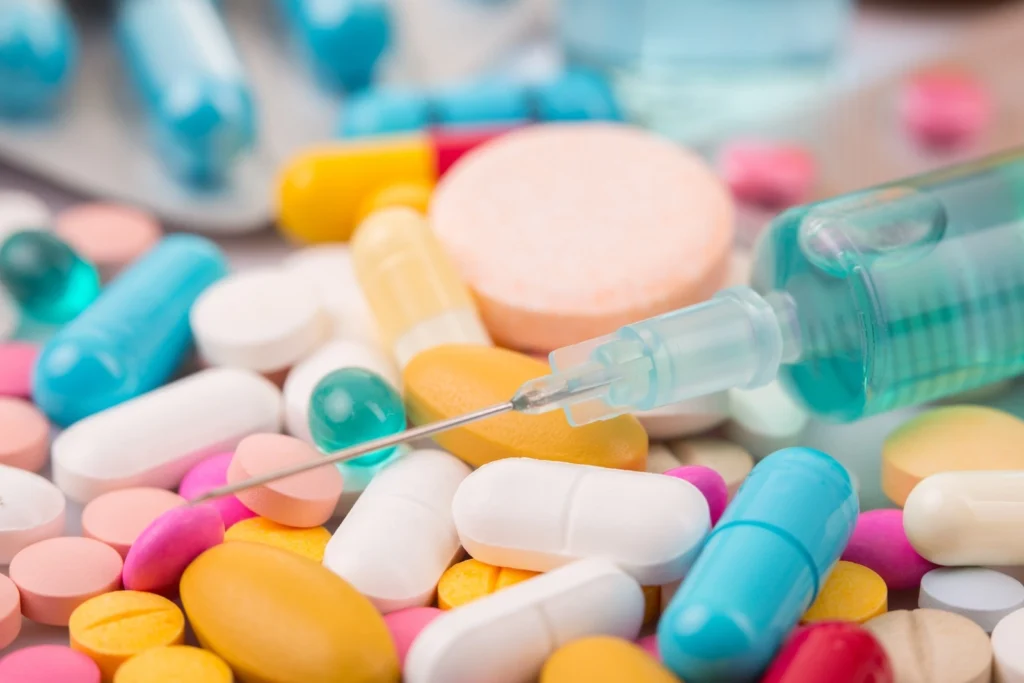 array of pills and a syringe