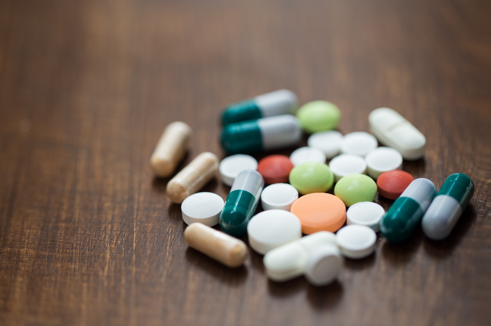 close up of different drugs in pills and capsules on table